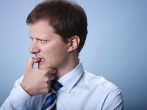 nervous business man biting finger nails