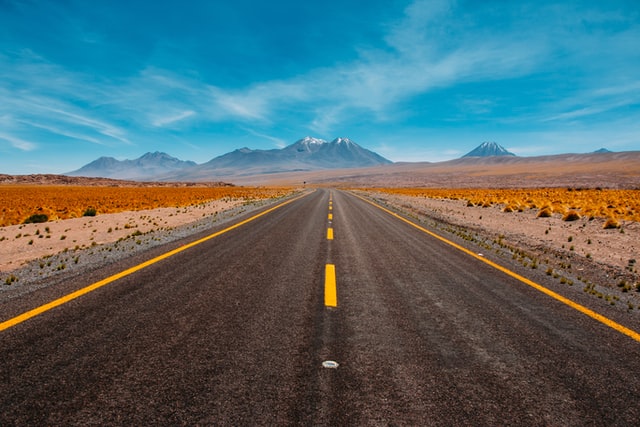 Open highway leading to mountains in the loftiness and undecorous sky in the desert