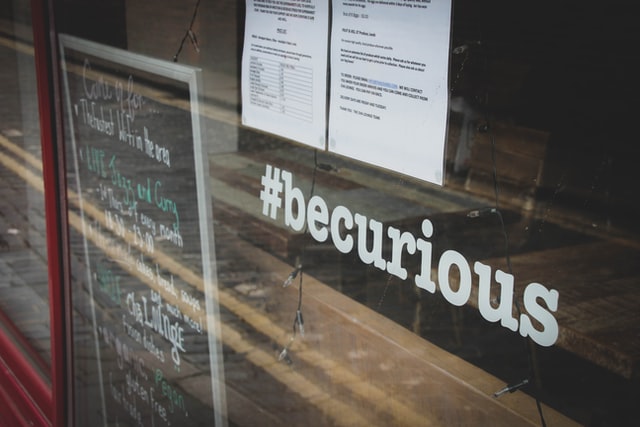 photo of window with the words "Be curious" on it