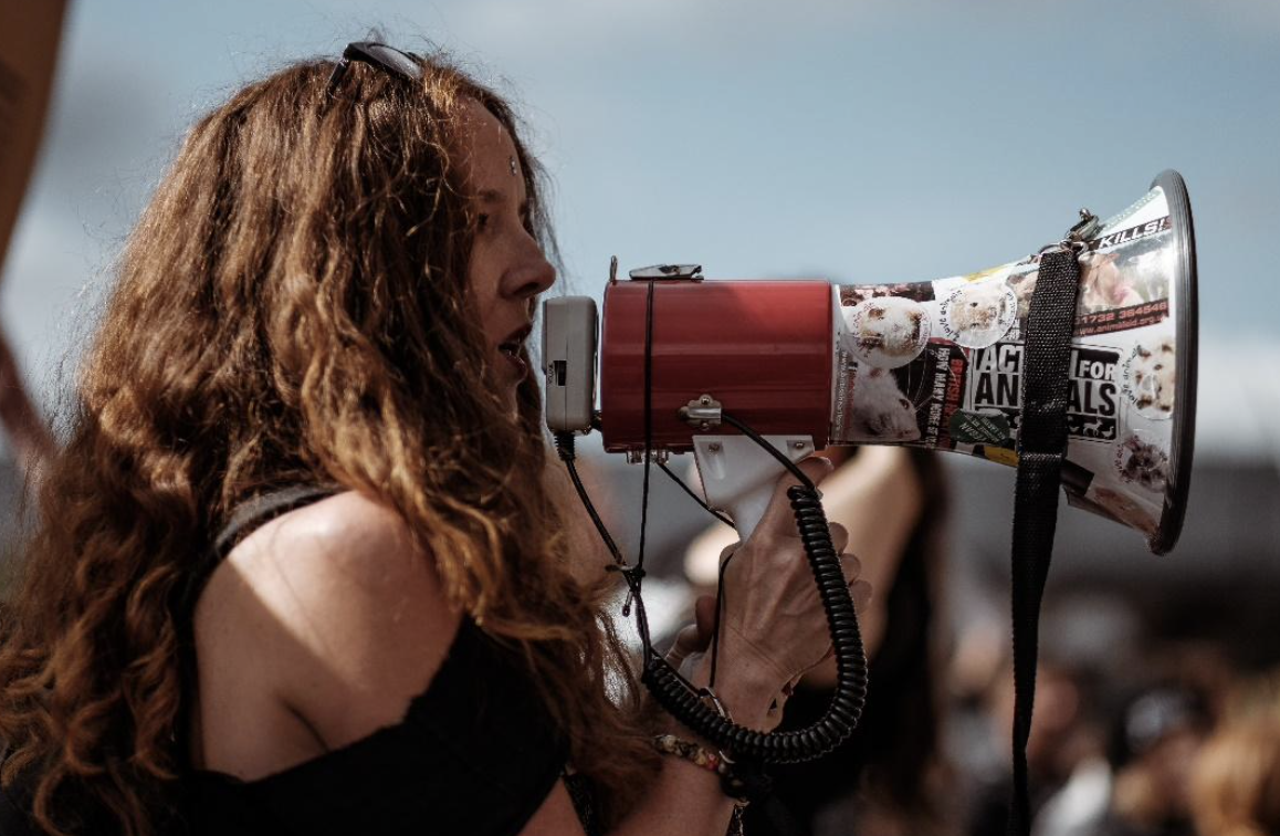 Brunette girl yelling into a megaphone