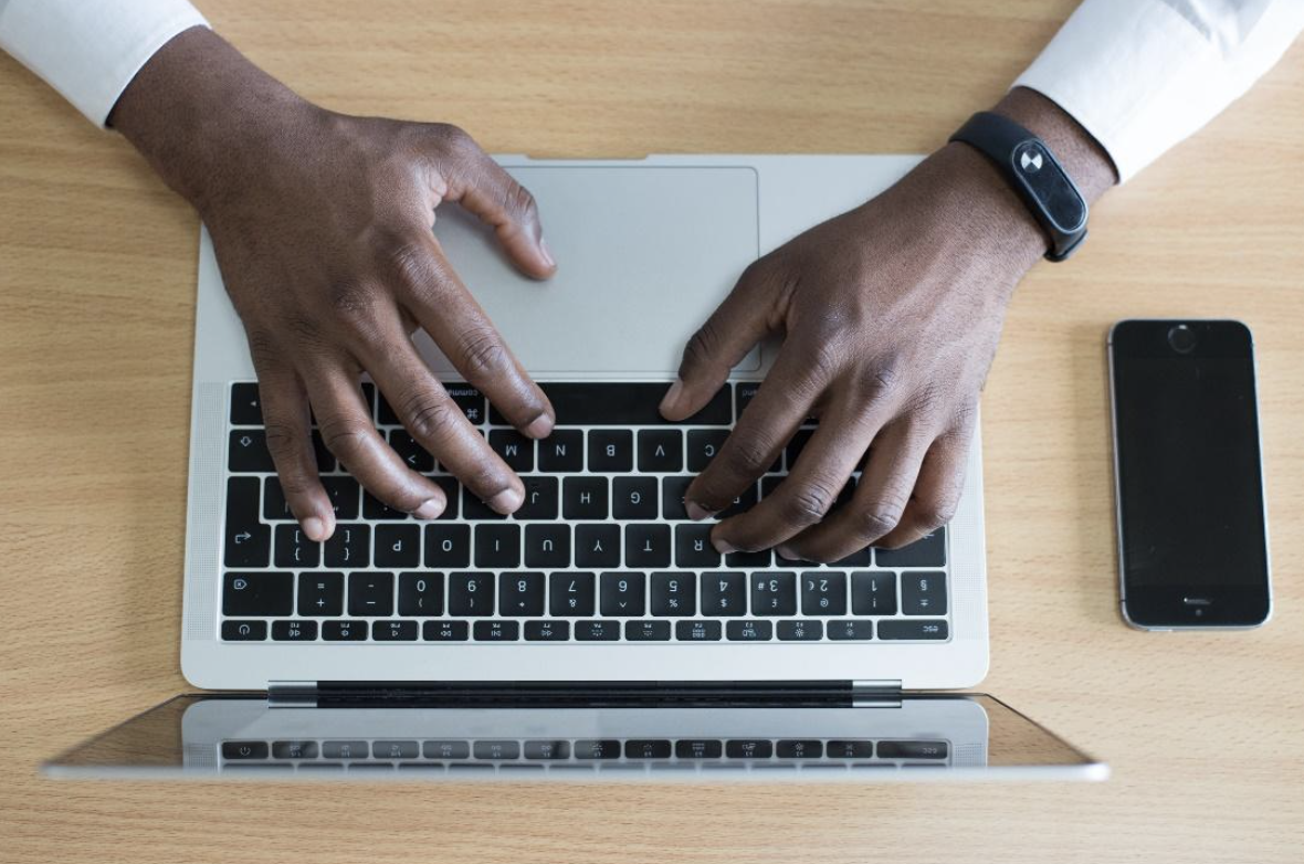 aerial view of a man's hands typing on a laptop computer